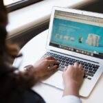 Woman sitting near a desk while using a MacBook